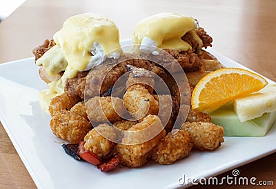 Fried chicken and waffles with eggs benedict on top Stock Photo