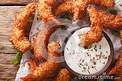Fried coconut shrimp close-up and a cream sauce on the parchment Stock Photo