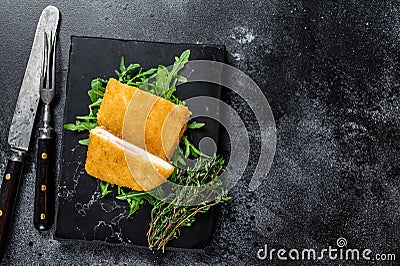 Fried cordon bleu meat chicken cutlet with ham and cheese. Black background. Top view. Copy space Stock Photo