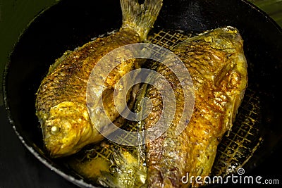 Fried crucians in a pan. Cooking fried fish. A dish of fried crucian carp. Tasty river fish Stock Photo