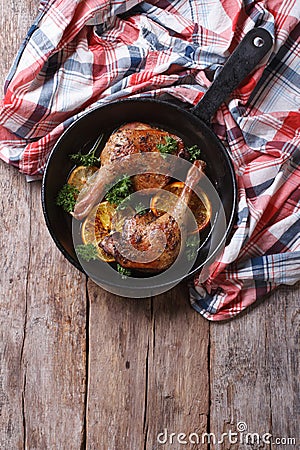 Fried duck legs with oranges, vertical top view, rustic style Stock Photo