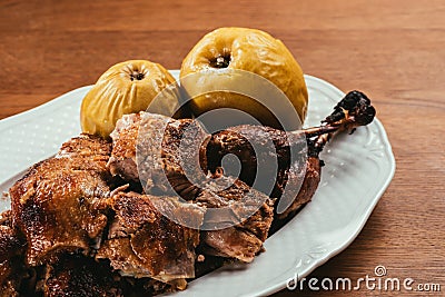 Fried duck pieces laying on plate with marinated apples Stock Photo