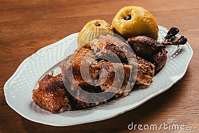 Fried duck pieces laying on plate with marinated apples Stock Photo