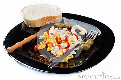 Fried egg on black plate isolated on white background.Eggs with kutchup,olives and bread Stock Photo