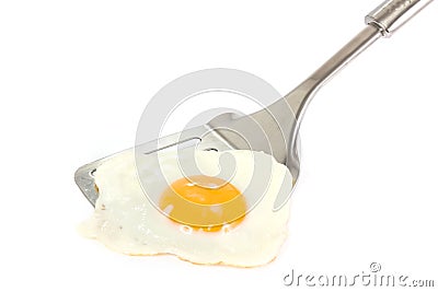 Fried egg on a silver spatula over white Stock Photo