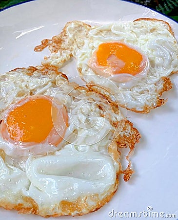 Fried egg is the simplest but delicious side dish. Stock Photo