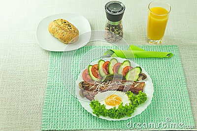 Fried eggs with bacon and fresh vegetables Stock Photo
