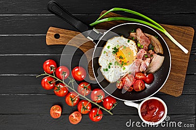 Fried eggs with ham in pan on black background. Stock Photo