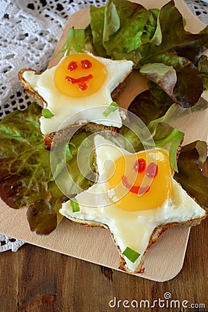 Fried eggs shaped as stars with funny faces Stock Photo