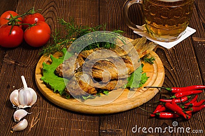 Fried fish with beer on wooden table Stock Photo