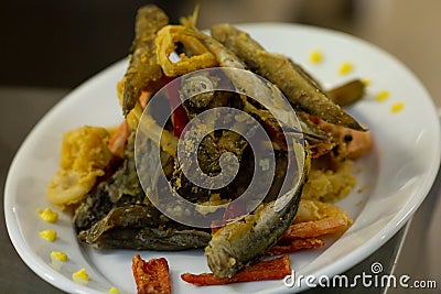 Fried fish in oil with calamar rings and pimiento peppers Stock Photo