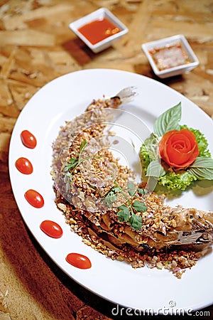 Fried fish served with garlic Stock Photo