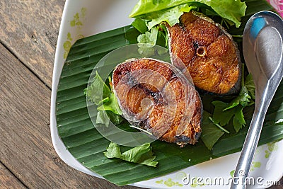 Fried Fish with Spicy Salad Dressing on wood table close up Stock Photo