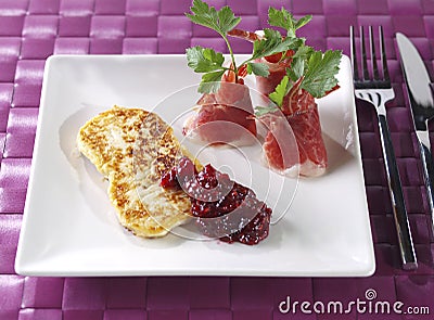 Fried fresh cheese with cured ham and rapsberry ma Stock Photo