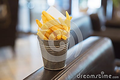 Fried golden French fries is packed into a small metal bucket Stock Photo