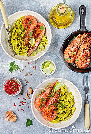 Fried king prawns with garlic, pepper, lime and parsley cilantro. Large shrimp. Langoustine. Delicious dinner with pasta tagliat Stock Photo