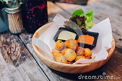 Fried Mozzarella Cheese Balls served with mayonnaise and thousand island sauce in wooden bowl Stock Photo