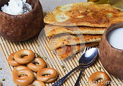 Fried pies, cheese, sunflower oil, milk and bagels on a plate cl Stock Photo