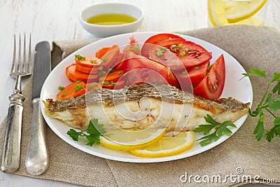 Fried plaice with lemon, parsley and salad Stock Photo