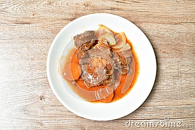 Fried pork bone with slice carrot and onion with swet and sour sauce on plate Stock Photo