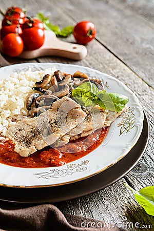 Fried pork cutlets with rice, tomato and mushrooms Stock Photo