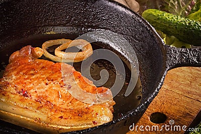 Fried pork steak on frying pan. Stock Photo