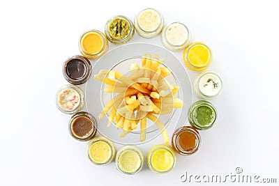 Top view french fries or fried potatoes with variety sauce dips in bottles on white floor. Stock Photo