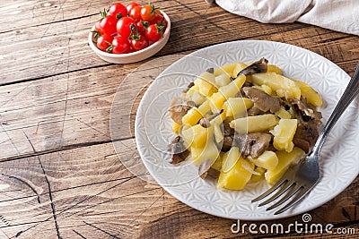 Fried potatoes with mushrooms and onions. Wooden table Copy sapce Stock Photo