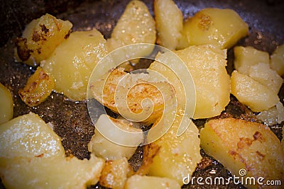 Fried potatoes in a pan with a golden brown mineral coating in vegetable oil. close-up photo Stock Photo