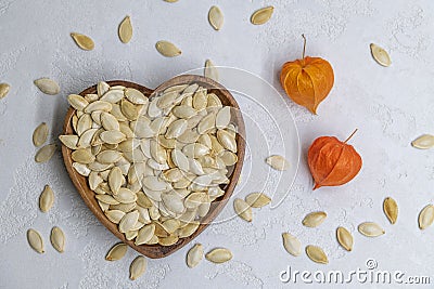 Fried pumpkin seeds on heart shaped wooden bowl Stock Photo