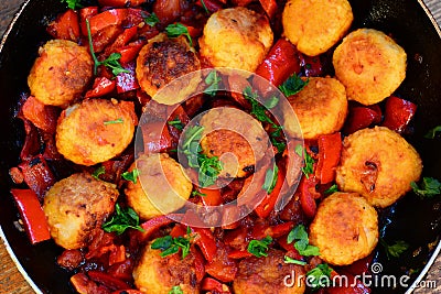 Fried rice balls with vegetables. Homemade fried rice balls with stewed red pepper, onions and tomatoes in a pan Stock Photo