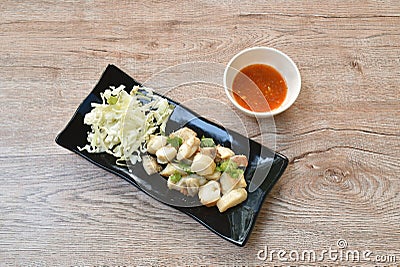 Fried squid egg or gonad with chop fresh cabbage on plate dipping spicy and sour sauce Stock Photo