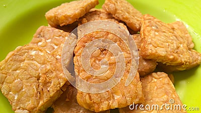 Fried tempeh on a green plate. Stock Photo