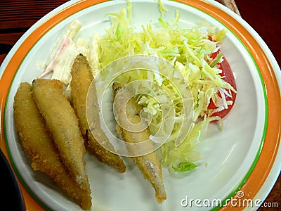 Fried whole fishes with lettuce tomato slices and mayonnaise salad sauce Stock Photo