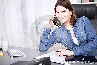 Friendly businesswoman smiling as she takes a call Stock Photo