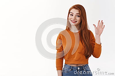Friendly cheerful good-looking girl redhead long hair smiling joyfully raise hand waving hello hi greeting gesture Stock Photo
