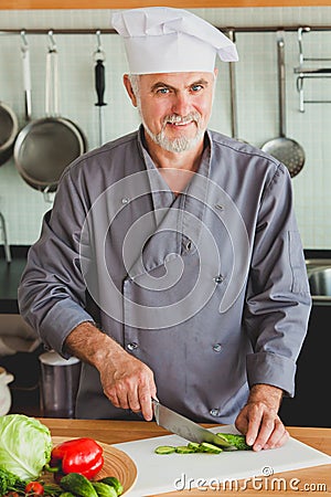 Friendly chef preparing vegetables in his kitchen Stock Photo