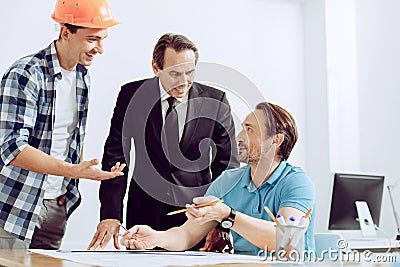 Friendly colleagues discussing an exciting story at the workplace Stock Photo