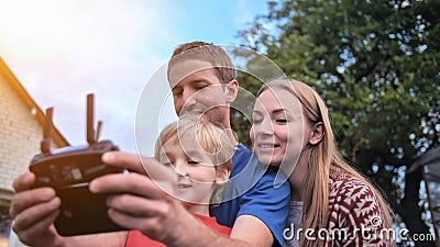 A friendly family launches a drone and controls it through the control panel. Stock Photo