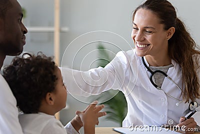 Friendly female doctor stroke head of cute african child boy Stock Photo