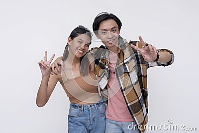 Friendly international freshman college students making peace signs. One Filipina lady and one chinese guy. Stock Photo
