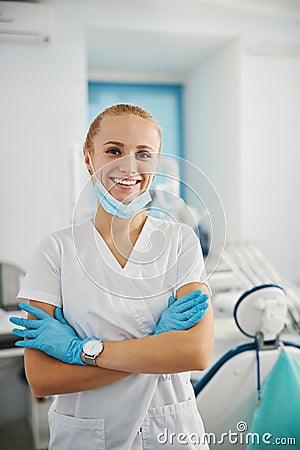 Welcoming stomatologist giving a smile while crossing arms Stock Photo
