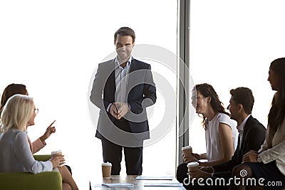 Friendly male leader having fun conversation with office workers team Stock Photo