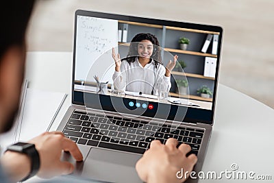 Friendly millennial afro american lady teacher explains rules to young caucasian male on laptop screen at home Stock Photo