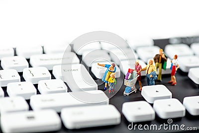 Friendly miniature family looking at computer keyboards. Technology concept Stock Photo