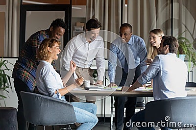 Friendly mixed race employees enjoying brainstorming activity in office. Stock Photo