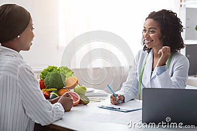 Friendly nutritionist giving consultation to patient about healthy feeding Stock Photo