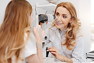 Friendly ophthalmologist explaining how equipment works Stock Photo