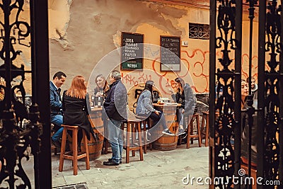 Friendly people meeting for lunch and drinks at outdoor cafe in historical area of city Editorial Stock Photo