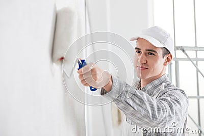 Friendly young male painter painting a wall Stock Photo